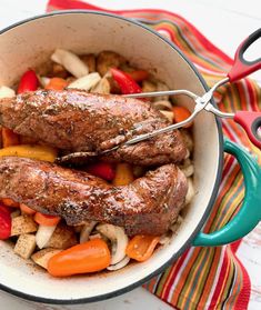 two sausages are being cooked in a pot with vegetables and meat on the side