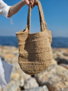 Discover Eco-Friendly Handmade Jute Beach Bag, perfect for summer vacations, this stylish and useful beach bag features a lining for added protection and large capacity to carry your family's essentials. Made from sustainable jute, it combines eco-friendliness with functionality,, making your beach days more enjoyable and organized. Model: Handmade Jute Beach/Everyday Bag Size: 30cm Height - 35 cm Width - Bottom 30 cm radius Material: Eco-Friendly Jute Rope Desing: Sustainable Summer Stylish Use Beachy Sand-colored Straw Bag, Sand-colored Straw Bag For Summer Beach, Beachy Sand-colored Beach Bag With Braided Handles, Spring Beach Sand-colored Straw Bag, Summer Sand-colored Straw Bag, Beige Crochet Bag With Large Capacity For Vacation, Summer Beige Bucket Bag For Daily Use, Trendy Beige Bucket Bag For Beach, Trendy Beige Bucket Bag For The Beach