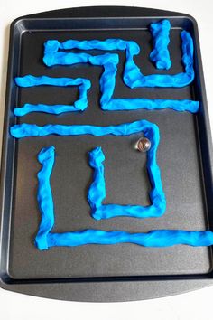 a cookie sheet with blue icing in the shape of mazes on top of it