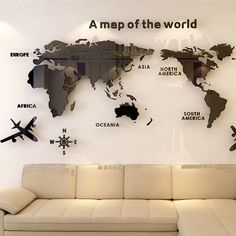 a couch sitting in front of a white wall with a world map on it's side