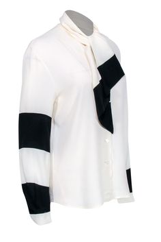 Go classic and chic with this neutral blouse by Louis Feraud! A silk blend button front boluses with color blocked sleeve details featuring black stripes. Pair with your wide leg black pants, a sleek sling back heel, and a colorful leather tote for a posh and polished everyday look! Size 4 60% Acetate, 40% Silk Button front Unlined V-neckline Long sleeve Color blocked design Tie at neckline Bust 40" Waist 40" Shoulder to hem 26" Sleeve length 24" Elegant Office Blouse With Striped Collar, Elegant Striped Blouse, Elegant White Blouse With Striped Collar, Elegant Office Tops With Striped Collar, Elegant Formal Tops With Striped Collar, Elegant Formal Top With Striped Collar, Chic Long Sleeve Blouse With Striped Sleeves, Elegant Striped Tops For Work, Elegant Striped Fall Blouse