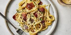 a plate of spaghetti with bacon and parmesan cheese