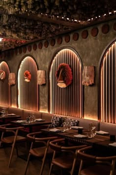 a restaurant with tables and chairs lined up against the wall, along with hanging decorations on the walls