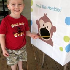 a young boy standing next to a sign with a monkey on it