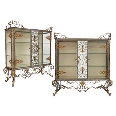 two mirrored cabinets with ornate designs and gold trimmings, one is open to the side