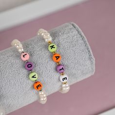 Customized bracelet made of freshwater white pearls and colorful letters. You can use the word/name up till 6 letters. Color of the letters will be picked randomly. Bracelet is stretchable and can be made with metal ball in gold either in silver color. This is a great present for yourself, relatives or friends and personalization will make it extra special.  Material and size: - Freshwater pearls - Plastic cubes with letters - Metal balls made of stainless steel - Length can be customized * As a Personalized Letter Beads Bracelets, Trendy Beaded Bracelets With Letter Print For Gift, Trendy Beaded Bracelets With Letter Print As Gift, Trendy White Name Bracelet For Gift, Trendy White Name Bracelet As Gift, White Custom Name Letter Bracelets, Custom Name White Letter Bracelets, Casual Name Bracelet With Letter Beads For Birthday, Gift Pearl Bracelet With Letter Beads