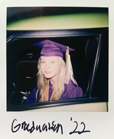 a young woman wearing a graduation cap and gown sitting in the back seat of a car