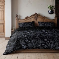 a bed with black comforter and pillows in a room