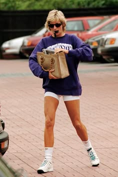 a woman is walking down the street with her purse