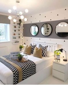 a bedroom with three round mirrors above the bed and black and white decor on the wall