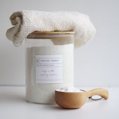 a wooden spoon sitting next to a jar filled with white powder