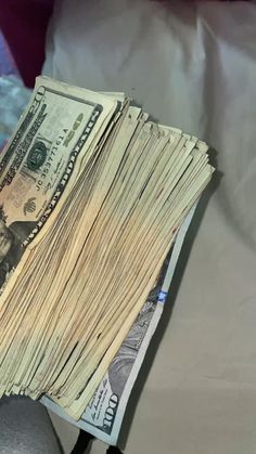 a stack of money sitting on top of a bed