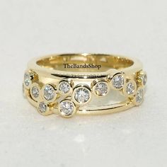 a yellow gold wedding band with diamonds on the sides and an inscription that reads, the handshop