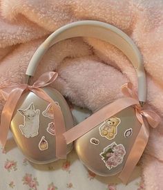 a pair of headphones sitting on top of a pink blanket next to a teddy bear