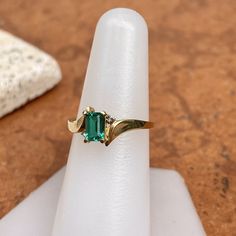 Estate/ vintage polished 10KT yellow gold ring with center, lab-created emerald + surrounding white diamonds. Timeless gold ring with a beautiful, vibrant green emerald! Size 7.25 Can be resized for an additional fee Weight: 1.8g (2) 1 pt genuine, white diamonds; SI clarity; H color Approx. 6mm x 4mm lab-created, green, rectangle center emerald Excellent estate condition 14k Gold Rectangular Emerald Anniversary Ring, Rectangular Solitaire Emerald Jewelry, Classic Green Birthstone Ring With Accent Stones, Classic Emerald Birthstone Ring With Accent Stones, Classic Rectangular Emerald Ring For May Birthstone, Fine Jewelry Yellow Gold Emerald Ring For May Birthstone, 14k Gold Emerald Cut Emerald Ring For May Birthstone, 14k Gold Green Rectangular Ring, Rectangular Emerald Ring In Yellow Gold