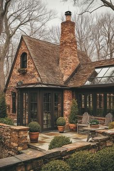 a brick house surrounded by trees and bushes