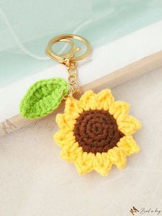 a crocheted keychain with a sunflower on it and a green leaf