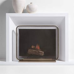 a fire place with two white vases on top