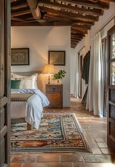 a bed sitting in a bedroom next to a wooden dresser under a light fixture on top of a tiled floor