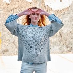 a woman with red hair is holding her hands to her head