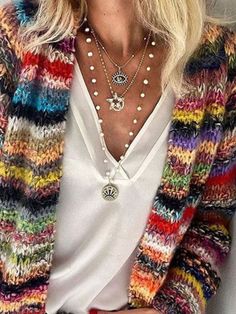 a woman with blonde hair wearing a multicolored cardigan sweater and white shirt