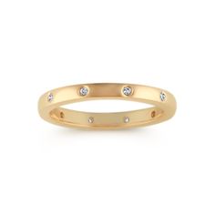 a yellow gold ring with three diamonds on the inside and outside, set against a white background