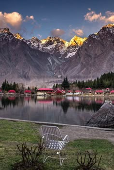 a bench sitting on top of a grass covered field next to a lake