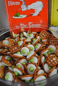 a bowl filled with pretzels next to a book