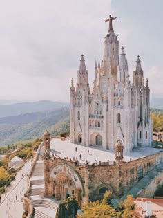 an aerial view of a large cathedral in the middle of a mountain range with stairs leading up to it