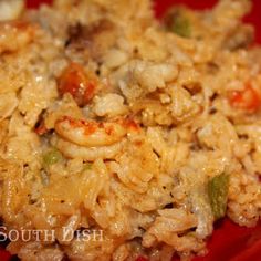 a red plate topped with rice and shrimp