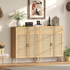 a wooden cabinet with two doors and some pictures on the wall above it in a living room