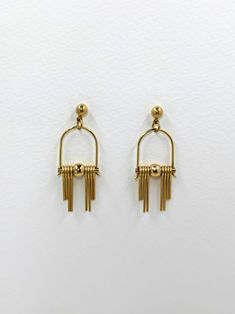 These Art Deco inspired earrings feature sleek, modern design elements, highlighting the radiant golden brass. Each earring boasts a distinctive arched geometric shape inspired by the Art Deco style, lending a sense of elegance and sophistication.  The stepped cut brass fringe creates movement and shine and adds to the uniqueness and contemporary design.  Their minimalist yet bold design embodies a harmonious balance between simplicity and intricacy, making them a versatile accessory suitable for both formal occasions and everyday wear. Each earring is finished with a brass ball stud with stainless steel post. Approximate measurements- 4.5 long 1.5cms wide These earrings are available in three variations- -Black Agate semi precious stone -Green Agate semi precious stone  -All Brass Please Modern Gold Dangle Chandelier Earrings, Modern Yellow Gold Dangle Chandelier Earrings, Modern Gold Chandelier Earrings With Ear Wire, Modern Gold Long Drop Hoop Earrings, Modern Gold Metal Chandelier Earrings, Modern Gold Chandelier Earrings Long Drop, Modern Gold Long Drop Chandelier Earrings, Modern Yellow Gold Linear Earrings, Modern Gold Dangle Threader Earrings