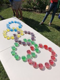 people standing around a table with cups on it and an olympic symbol painted on the table