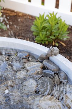 rocks are placed on top of each other in a bucket filled with water and gravel