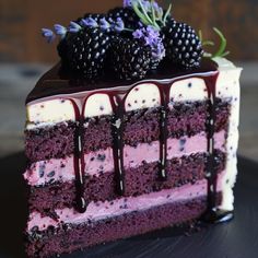 a slice of cake with berries and chocolate drizzle