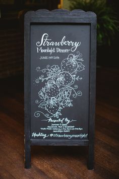 a chalkboard sign sitting on top of a wooden table