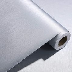 a roll of metallic paper on top of a white surface