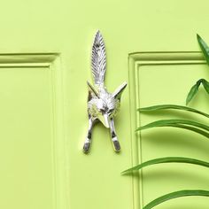 a green door with a metal bird decoration on it