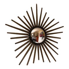 a sunburst shaped mirror is hanging on the wall in front of a white background