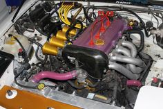 the engine compartment of a car with many different types of pipes and hoses on it