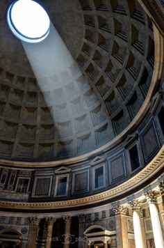 the sun shines brightly through a round window in an old building's dome