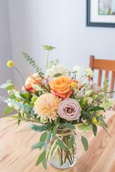 a vase filled with flowers sitting on top of a wooden table