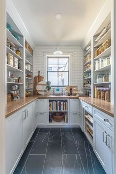 a kitchen with lots of white cabinets and shelves