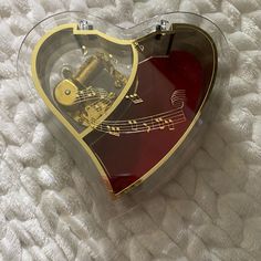 a heart shaped music box with musical notes on the inside and in the shape of a guitar