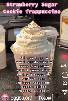 an ice cream sundae with sprinkles in a plastic cup on a counter