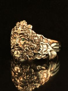 This intricately detailed Green Man Ring is cast in 14K gold. Two 1.25mm Tsavorites are set in the Green Man's eyes. Tsavorites are a clearer and brighter green than most emeralds and add considerable sparkle to the ring. Oak leaves and acorns make up the substantial band. The ring is 3/4" wide at the top, tapering down to 3/16" at the base of the shank. The Green Man is a symbol of rebirth and a symbol of seasonal renewal. Although the Green Man may appear to be a pagan image, it has been a dec Gold Nature-inspired Emerald Ring As A Gift, Nature-inspired Gold Emerald Ring As A Gift, Nature-inspired Gold Emerald Ring As Gift, Nature-inspired Gold Emerald Ring Gift, Nature-inspired Gold Emerald Ring For Gift, 14k Gold Art Nouveau Ring Jewelry, Heirloom Yellow Gold Tsavorite Ring, Heirloom Tsavorite Yellow Gold Ring, Gold Emerald Ring With Nature-inspired Style