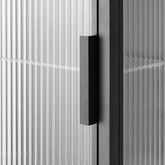 a black and white photo of a door with vertical blinds on the outside, as seen from behind