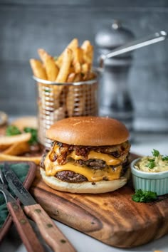 a cheeseburger with fries on a cutting board