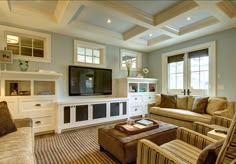 a living room filled with furniture and a flat screen tv mounted on a wall above a fireplace