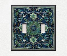 a decorative light switch cover with flowers and leaves on the front, painted in dark blue